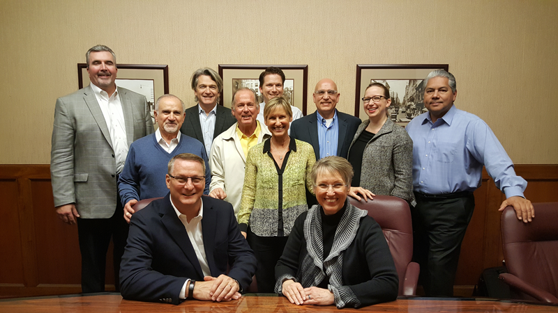 Michael Cash (seated left), Senior Vice President and President, Industrial Coatings of Axalta Coating Systems and Sandy Berg, President and CEO of Ellis Paint Company, joined by members of Axalta and Ellis management.