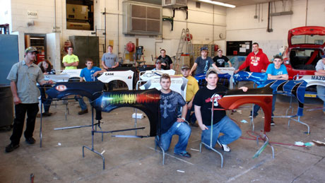 Students from Nichols Career Center pose with fenders they custom painted as part of their training at the Missouri school. 