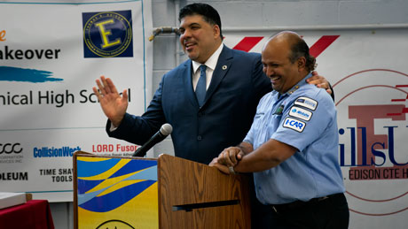 Moses Ojeda (left) introduces Barry Roopnarine, Thomas Edison Career and Technical High School’s Collision Repair and Refinishing Technology instructor, during the Collision Repair Education Foundation Makeover Grant ribbon cutting ceremony held May 18.