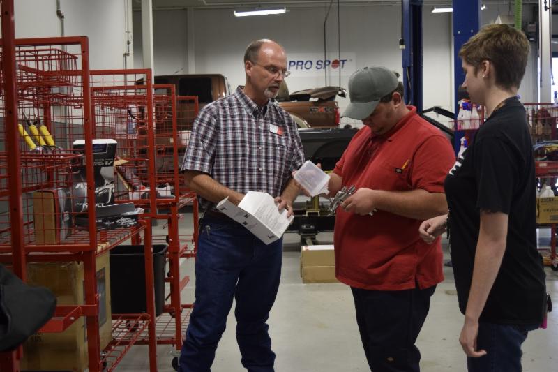 (Left to right) Kevon Kleibrink, an instructor in the Auto Collision and Management Technology program at Texas State Technical College in Waco, talks to Auto Collision Management and Technology majors (center) Justin Hathcock of Hico and (right) Victoria Betts of Whitehouse about new equipment. 